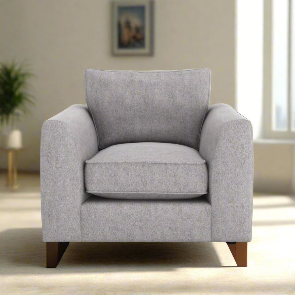 A gray fabric upholstered armchair with a plush backrest and seat cushion, standing on a white background.