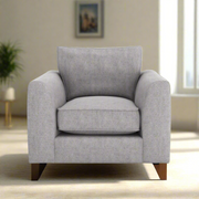 A gray fabric upholstered armchair with a plush backrest and seat cushion, standing on a white background.